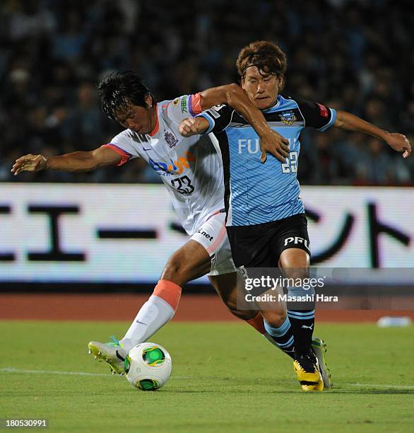 Kyohei Noburizato of Kawasaki Frontale and Tsukasa Shiotani of Sanfrecce Hiroshima compete for the ball during the J.League match between Kawasaki...