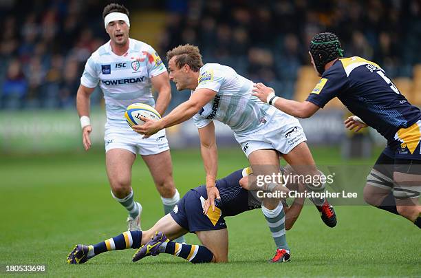 Andrew Fenby of Irish passes the ball as he is tackled by Paul Hodgson of Warriors during the Aviva Premiership match between Worcester Warriors and...