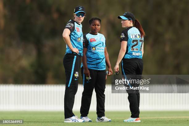 Anesu Mushangwe of the Strikers talks to Tahlia McGrath and Meghan Schutt of the Strikers before bowling the final over during the WBBL match between...