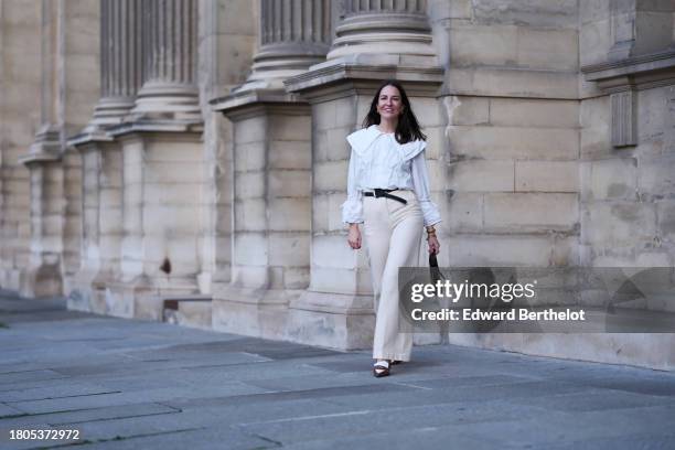 Alba Garavito Torre wears a white large collar and puffy sleeves with bow shirt, ivory high waist wide legs pants from Nina Blanc, brown and white...