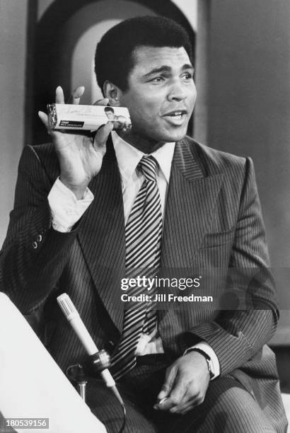 American heavyweight boxer Muhammad Ali shows his new protein bar on national television, New York City, 1977.