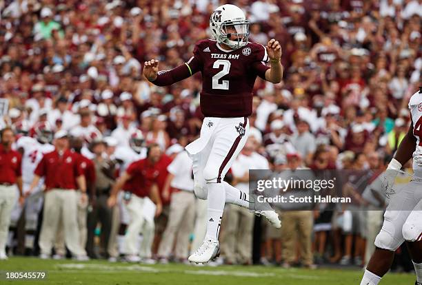 Johnny Manziel of the Texas A&M Aggies jumps after throwing a first quarter touchdown during a game against the Alabama Crimson Tide at Kyle Field on...