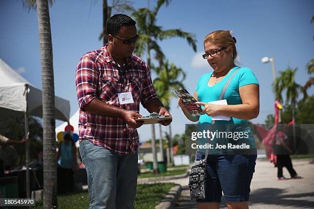 Milton Vazquez , an organizer for 'Get Covered America', speaks with Mayra Leon at the Hialeah Literacy Fair September 14, 2013 in Hialeah, Florida....