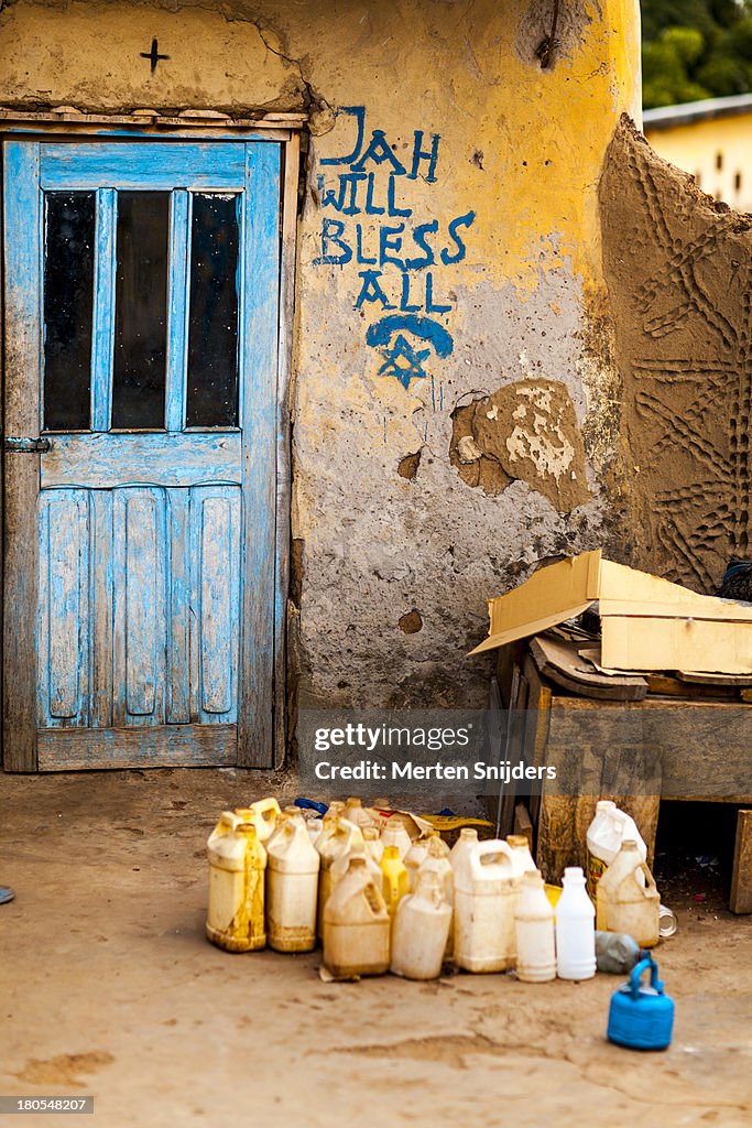 Water jerrycans and religious wall depiction