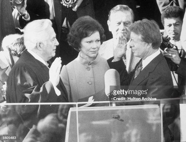 Democrat Jimmy Carter is sworn in by chief justice Earl Burger as the 39th president of the United States while first lady Rosalynn looks on,...