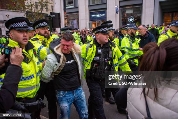 Police officers arrest the far-right English Defence League founder Tommy Robinson outside the Royal Court of Justice in London during the march....