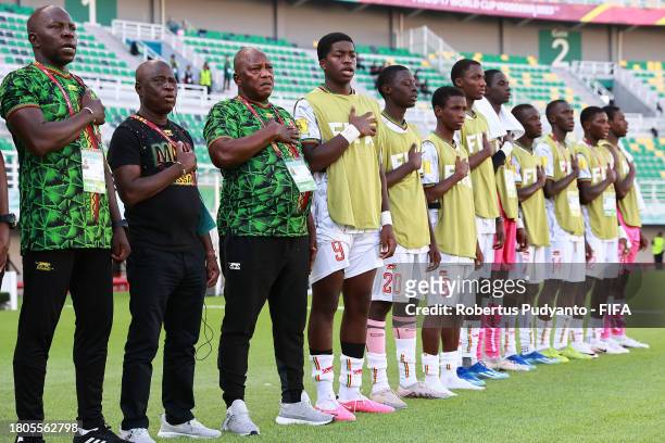 Coaching staff of Mali and substitute players participate in the national anthem prior to the FIFA U-17 World Cup Round of 16 match between Mali and...