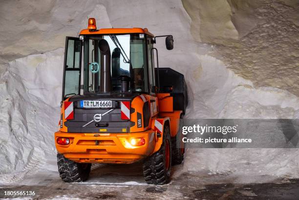 November 2023, Rhineland-Palatinate, Welschbillig: An excavator loads road salt in a hall belonging to Landesbetrieb Mobilität. In the morning, it...