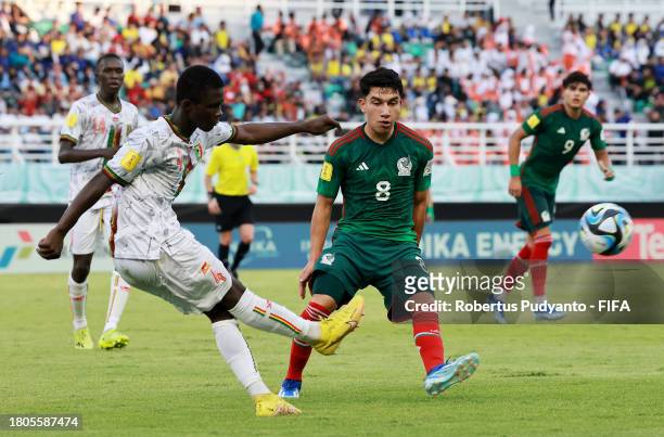 Souleymane Sanogo of Mali shoots past Jose Urias of Mexico during the FIFA U-17 World Cup Round of 16 match between Mali and Mexico at Gelora Bung...