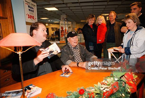 Jürgen Roland, Andreas Ellermann,;Signierstunde, Möbelpark Sachsenwald,;Bentdorf bei Hamburg, Deutschland,;Publikum, Blumen, Dekoration,...