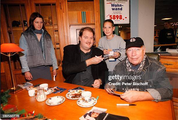 Jürgen Roland, Andreas Ellermann,;Signierstunde, Möbelpark Sachsenwald,;Bentdorf bei Hamburg, Deutschland,;Publikum, Tasse, Kekse, Tisch, Mütze,