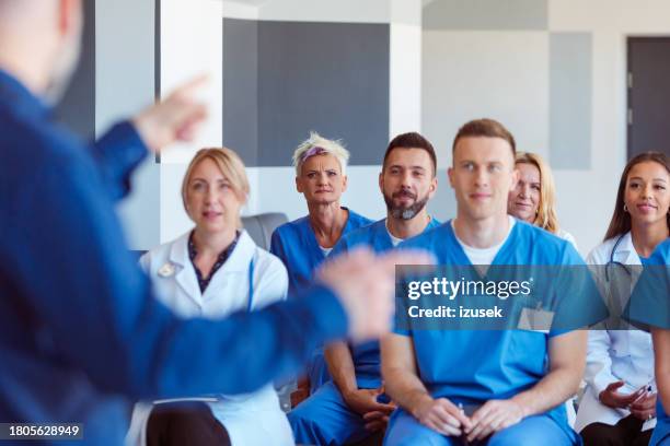 gruppe von ärzten und krankenschwestern, die an einem gesundheitsseminar teilnehmen - krankenpfleger stock-fotos und bilder