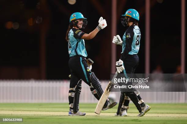 Amelia Kerr of the Heat celebrates with Charli Knott during the WBBL match between Brisbane Heat and Sydney Sixers at Allan Border Field, on November...