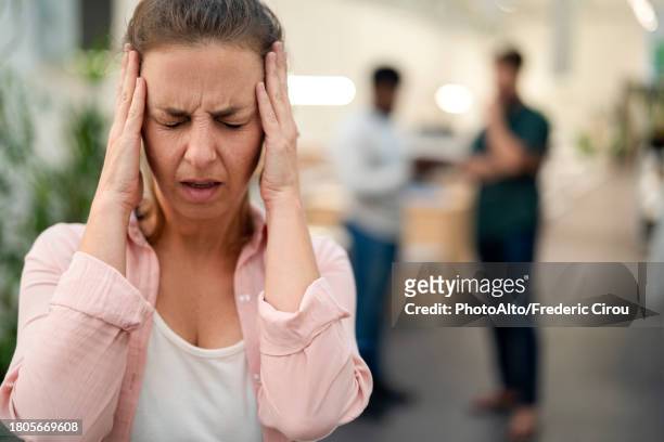 adult woman with hands on face having a headache - headache imagens e fotografias de stock