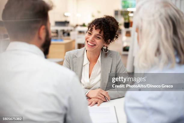 cheerful female bank worker having a meeting with two clients - bankieren stockfoto's en -beelden