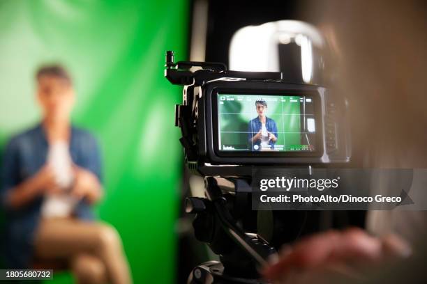 over shoulder view of professional video camera filming an interview - filmare foto e immagini stock