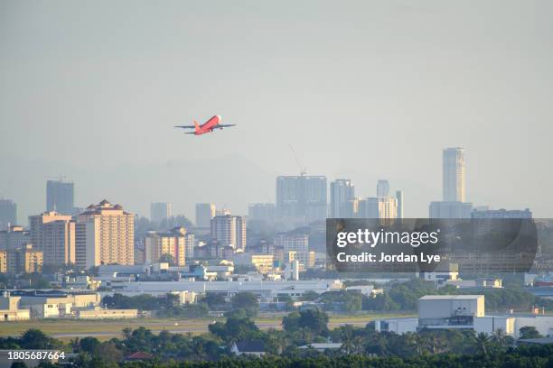 red plane taking off with cityscape - plane taking off stock pictures, royalty-free photos & images