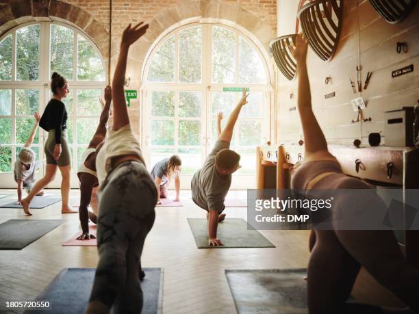 fitness, stretching and people in yoga class for exercise for health and wellness. group, workout and training body in pilates practice or instructor in gym studio for mobility or flexibility - pases stock pictures, royalty-free photos & images