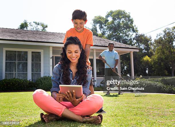 mother and son using laptop with father - rechen stock-fotos und bilder