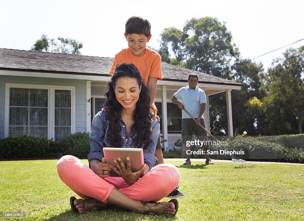 Mother And Son Using Laptop With Father