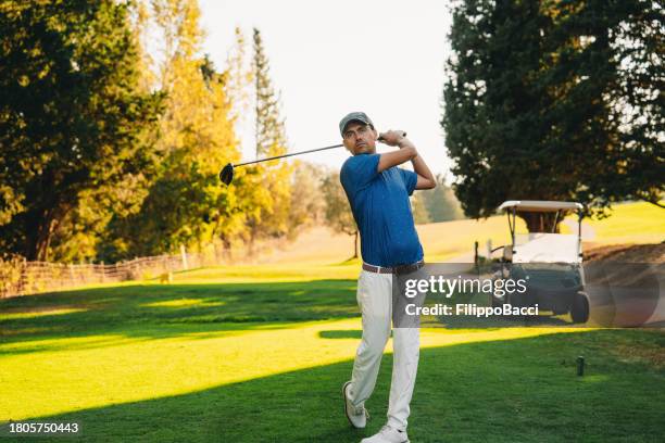 a golfer just after shooting the ball - golfspelare bildbanksfoton och bilder