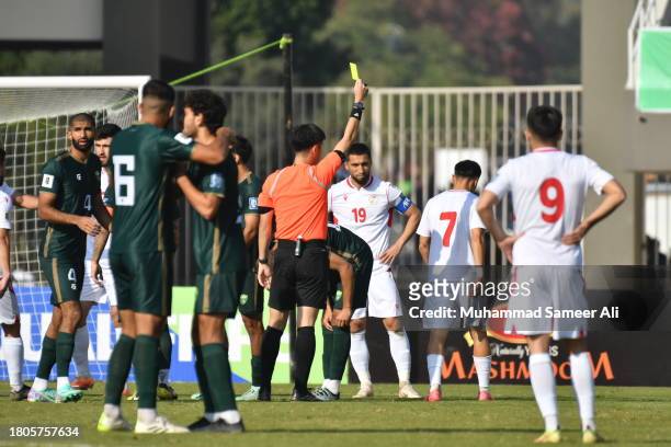 The Referee gives a yellow card to 7# Parvizdzhon Umarbaev of Tajikistan during the 1st half of the 2026 FIFA World Cup AFC Qualifier Group G match...