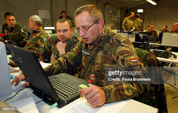 Major Huub Van Leevwen with the Dutch forces, International Security Assistance Force works on his computer alongside Major Sybens from Belguim at...