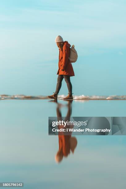 girl on beach looking at her reflection - self reflection stock pictures, royalty-free photos & images