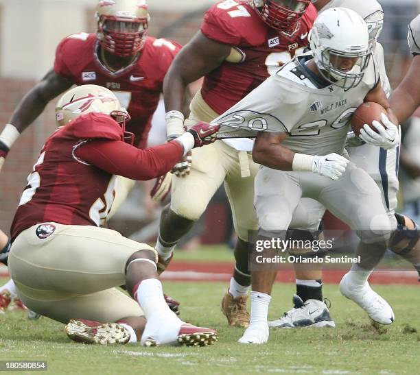 Florida State defensive tackle Jacobbi McDaniel, left, pulls on the jersey of Nevada running back Chris Solomon during game action at Doak Campbell...