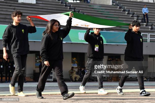 Volunteers carry a Tajikistan flag towards the ground during the 2026 FIFA World Cup AFC Qualifier Group G match between Pakistan and Tajikistan at...