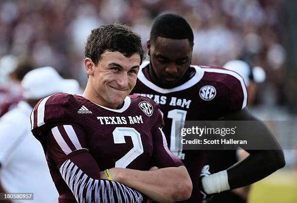Johnny Manziel of Texas A&M Aggies waits near the bench in the fourth quarter during the game against the Alabama Crimson Tide at Kyle Field on...