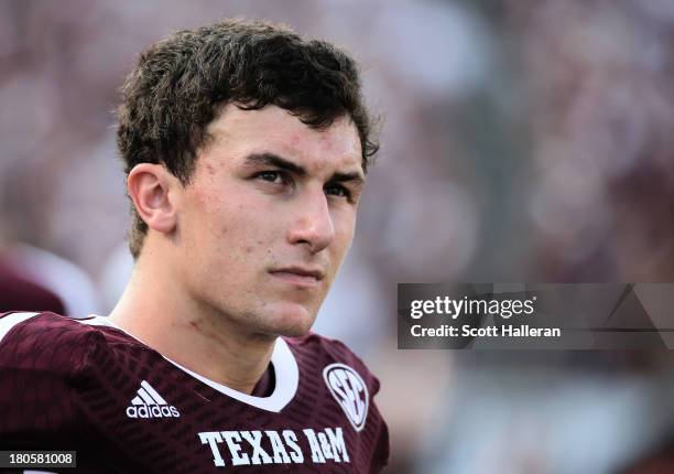 Johnny Manziel of Texas A&M Aggies waits near the bench in the fourth quarter during the game against the Alabama Crimson Tide at Kyle Field on...