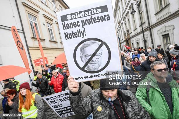 Demonstrators hold a placard reading 'The end of the Czech PM Petr Fiala - professor Nutella' as they take part in a protest called by the Czech's...