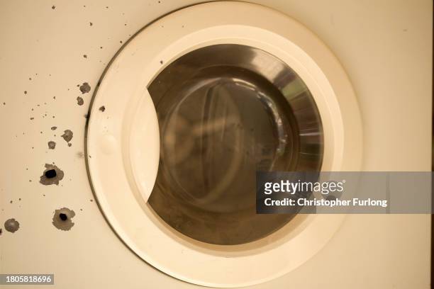 Bullet holes in a washing machine are seen after the October 7th Hamas attacks at Kibbutz Kfar Aza close the Gaza border. Forensic analysis and...