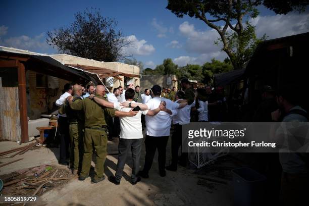 Israeli men and soldiers sing religious songs at Kibbutz Kfar Aza close the Gaza border which was attacked by Hamas in the October 7th attack on...