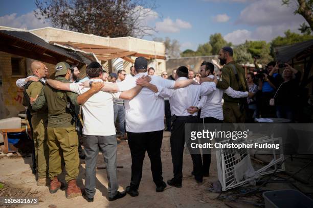 Israeli men and soldiers sing religious songs at Kibbutz Kfar Aza close the Gaza border which was attacked by Hamas in the October 7th attack on...