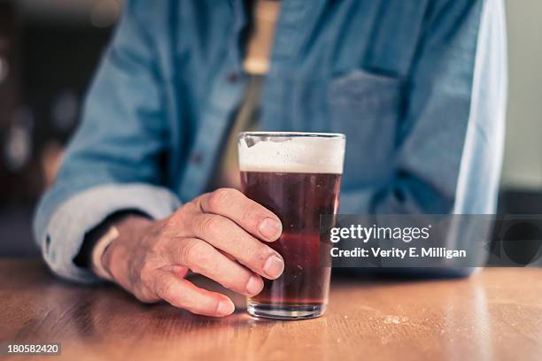 older man holding glass for beer - half full stock pictures, royalty-free photos & images