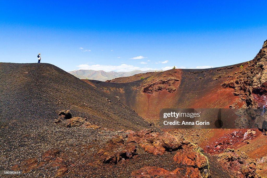 Hiker stands on hill at Craters of the Moon, Idaho