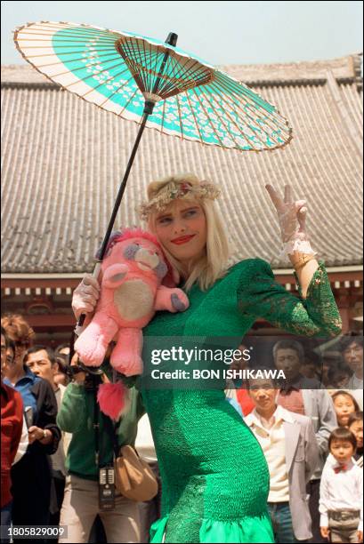 Ilona Staller, 37 years old Italian parliamentarian and porn star, known as "Cicciolina", smiles under a japanese paper umbrella during a visit to...