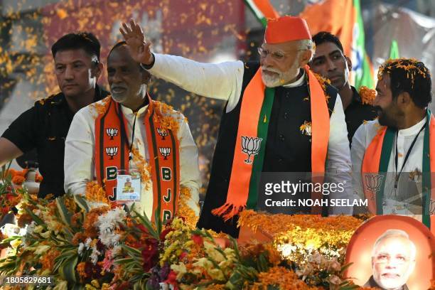 India's Prime Minister Narendra Modi waves to supporters during a road show as a part of Bharatiya Janata Party's election campaign ahead of the...
