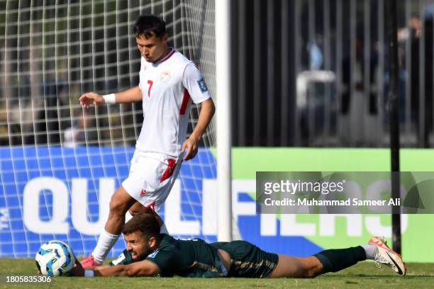 Rahis Nabi from Pakistan falls on ground while Parvizdzhon Umarbaev from Tajikistan approaches towards ball during the 2026 FIFA World Cup AFC...