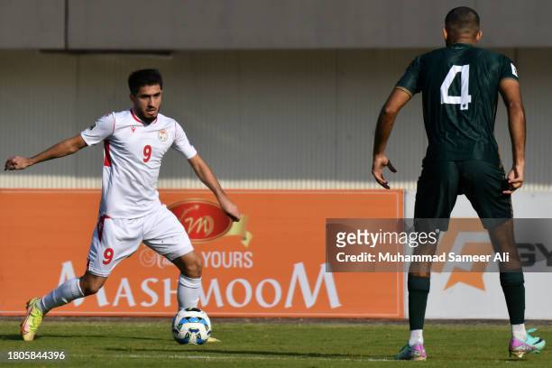 Rustam Soirov of Tajikistan tries to pass through Abdullah Iqbal of Pakistan during the 2026 FIFA World Cup AFC Qualifier Group G match between...