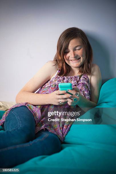 tween girl on her bed with smart phone - kid sleeveless stock pictures, royalty-free photos & images