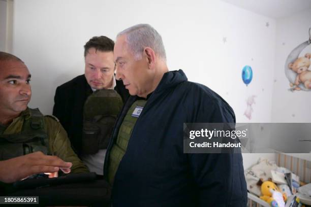 In this handout image provided by the GPO, Israel's Prime Minister Benjamin Netanyahu takes Elon Musk on a tour of Kibbutz Kfar Aza after the October...