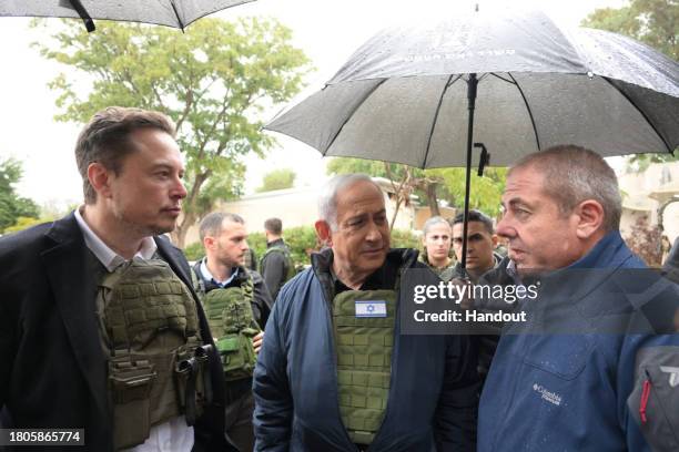 In this handout image provided by the GPO, Israel's Prime Minister Benjamin Netanyahu takes Elon Musk on a tour of Kibbutz Kfar Aza after the October...