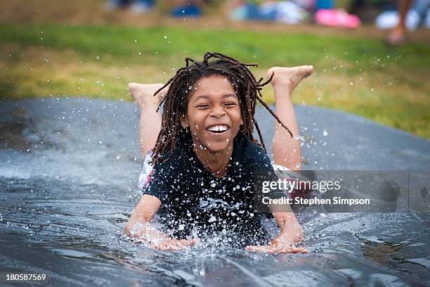 laughing boy on schoolyard slip n slide - slip and fall - fotografias e filmes do acervo