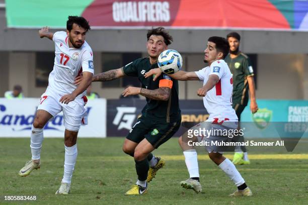 Ehson Panshanbe, #14 Burizod Alijoni of Tajikistan & #7 Otis Khan of Pakistan stopping each other to reach towards the ball during the 2026 FIFA...