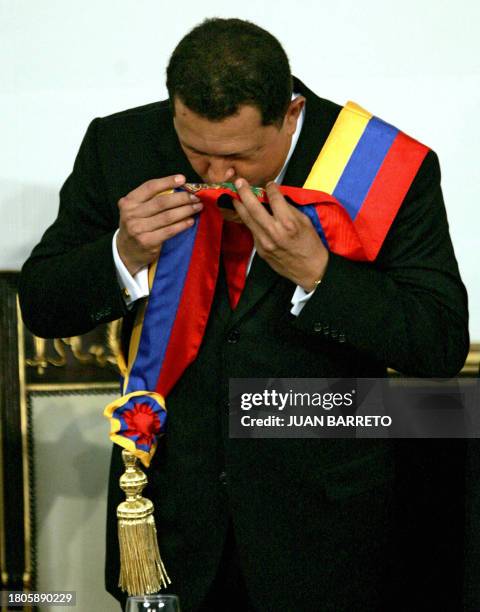 Venezuelan President Hugo Chavez kisses the ceremonial sash during the inauguration ceremony in Caracas 10 January 2007. Chavez, a harsh critic of...