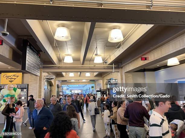 Crowded indoor ferry terminal with pedestrians and food vendors, Ferry Building Marketplace, Port of San Francisco, California, August 17, 2023.