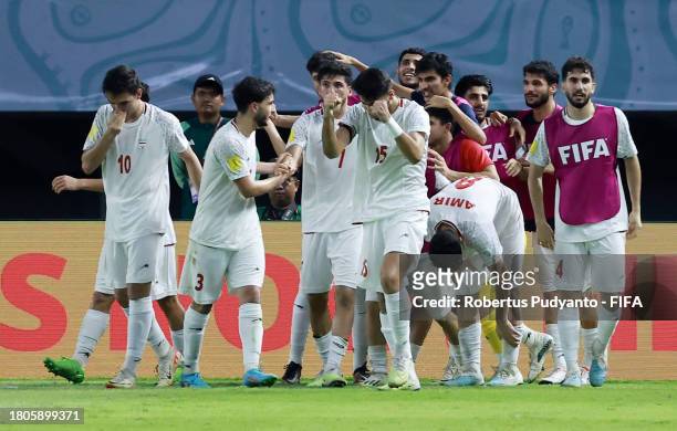 Esmaeil Gholizadeh of IR Iran celebrates with teammates after scoring the team's first goal during the FIFA U-17 World Cup Round of 16 match between...